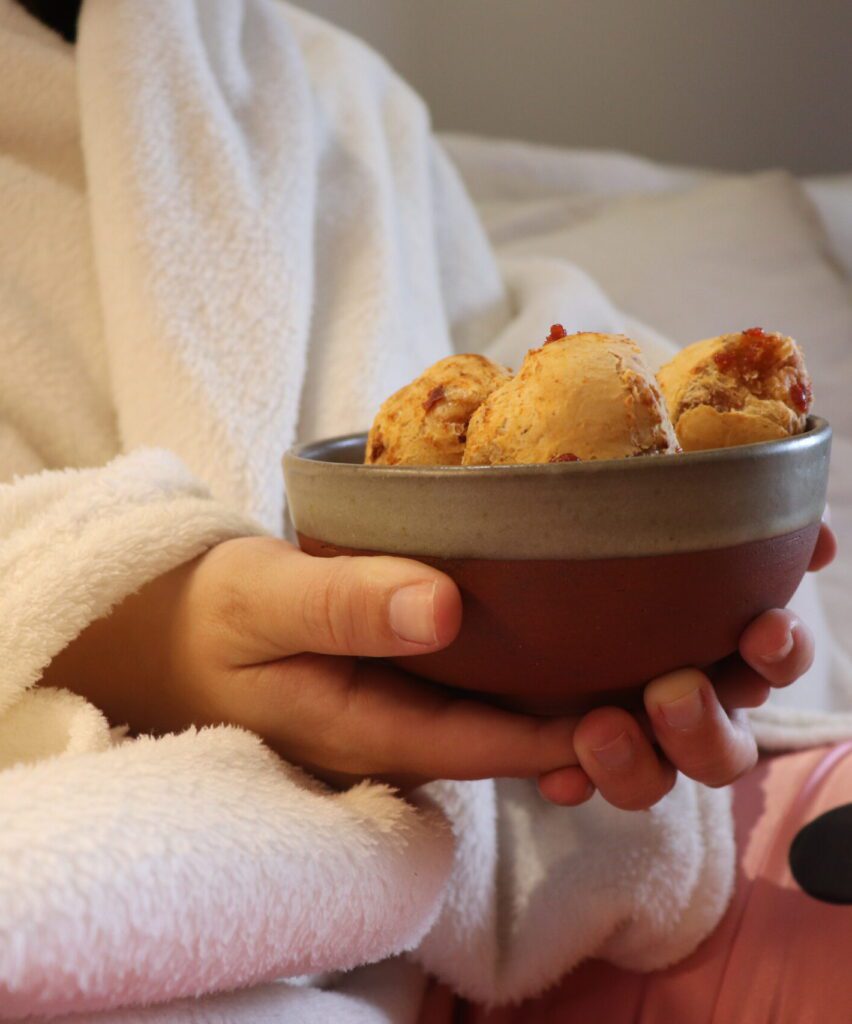 Pessoa segurando recipiente com Não de Queijo